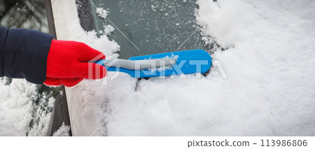 Hand using brush and remove snow from car and windscreen. Problems in winter 113986806