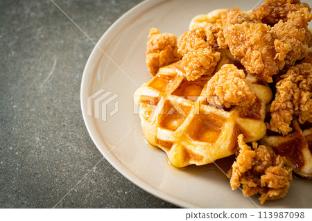 fried chicken waffle with honey or maple syrup 113987098