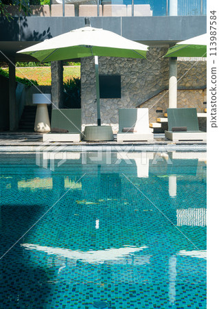 bed pool with umbrella around swimming pool 113987584