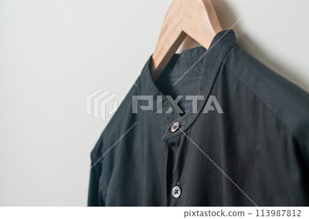 hanging shirt with wood hanger on wall 113987812