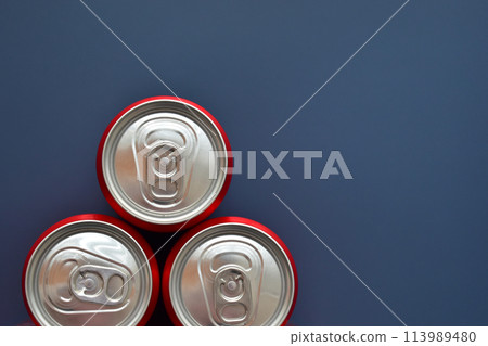 close up group of aluminium red cans soft drink put on blue texture background 113989480
