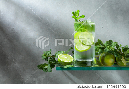 Mojito with ice, lime, and mint on a grey background. 113991300