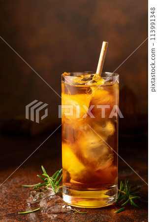 Cocktail with ice, rosemary and lemon slices on the old brown table. 113991348