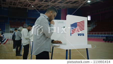 African American voter with bulletin comes to voting booth 113991414