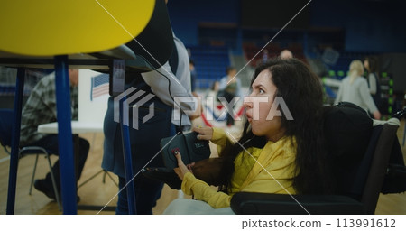 Woman with SMA votes during election using remote buttons Woman with SMA votes during election using remote buttons 113991612
