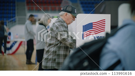 Male voter with bulletin in hands comes to voting booth 113991616