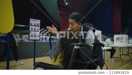 Female US voter with SMA uses remote buttons and votes on tablet Female US voter with SMA uses remote buttons and votes on tablet 113991619
