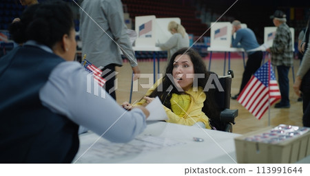 Woman with SMA comes and talks with polling officer Woman with SMA comes and talks with polling officer 113991644