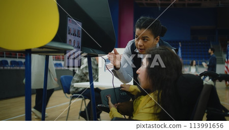 Female US voter with SMA uses remote buttons and votes on tablet 113991656