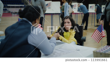 Woman with SMA comes and talks with polling officer 113991661