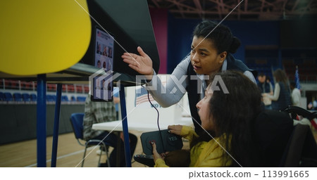 Female US voter with SMA uses remote buttons and votes on tablet Female US voter with SMA uses remote buttons and votes on tablet 113991665