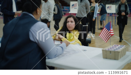 Woman with SMA comes and talks with polling officer Woman with SMA comes and talks with polling officer 113991671