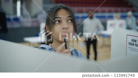 African American young female voter comes to voting booth African American young female voter comes to voting booth 113991749