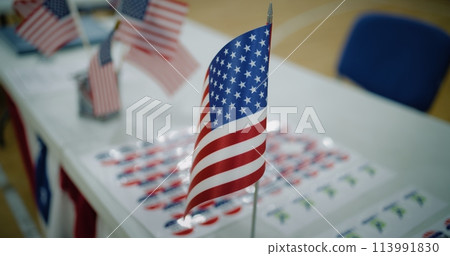 Close up of American flag standing on the table at polling place 113991830