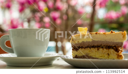 Spring cafe and cup of coffee in pink magnolia flowers. Spring cafe and cup of coffee in pink magnolia flowers. 113992514