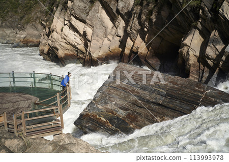 asian woman looking at the rapid currents of tiger leaping gorge in yunnan, china asian woman looking at the rapid currents of tiger leaping gorge in yunnan, china 113993978