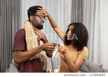 Caring Woman Comforting Ill Man With Cold At Home Caring Woman Comforting Ill Man With Cold At Home 113994065