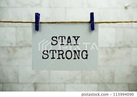 Stay Strong text on paper card hanging on the wall with Clothespins Stay Strong text on paper card hanging on the wall with Clothespins 113994090
