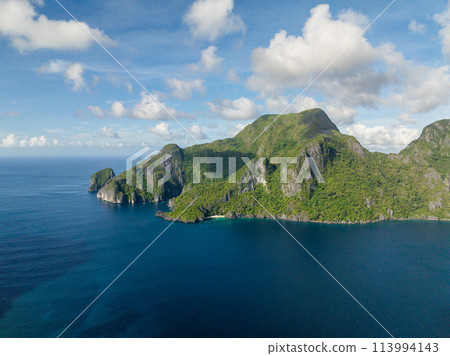 Cadlao Island with beach and blue sea. Blue sky and clouds. El Nido, Philippines. Cadlao Island with beach and blue sea. Blue sky and clouds. El Nido, Philippines. 113994143