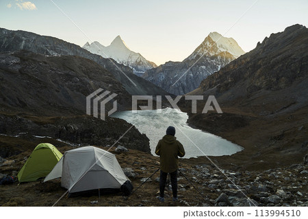 asian photographer taking a photo of mountain and lake in yading national park 113994510