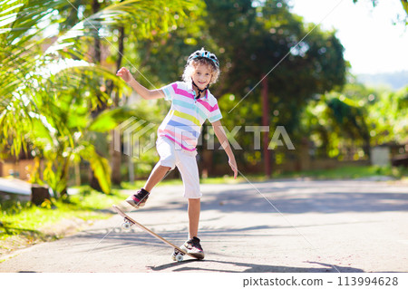 Kid with skateboard. Child riding skate board. 113994628