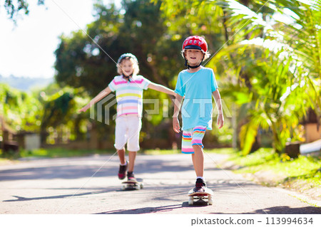 Kid with skateboard. Child riding skate board. 113994634