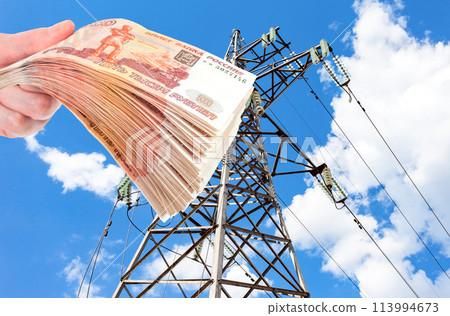 High voltage line and stack of russian rubles in the hand 113994673