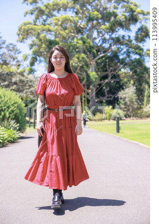 A young Japanese woman walking in a park in Sydney 113995409