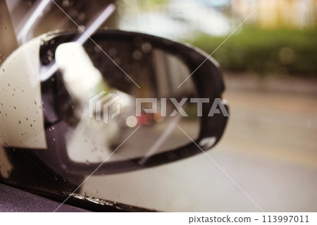 the wing of right side rear viewer mirror of the car on street 113997011
