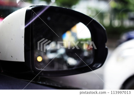 the wing of right side rear viewer mirror of the car on street the wing of right side rear viewer mirror of the car on street 113997013