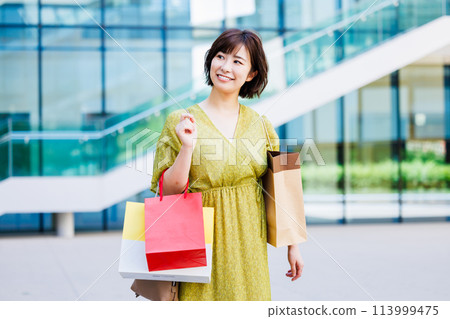 A woman in a dress enjoying shopping A woman in a dress enjoying shopping 113999475