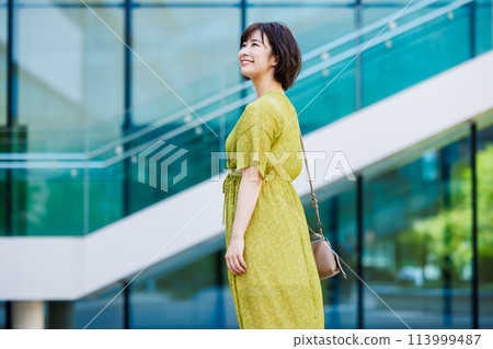 A young woman in a dress walking outdoors A young woman in a dress walking outdoors 113999487