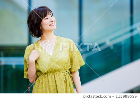 A young woman in a dress walking outdoors A young woman in a dress walking outdoors 113999559