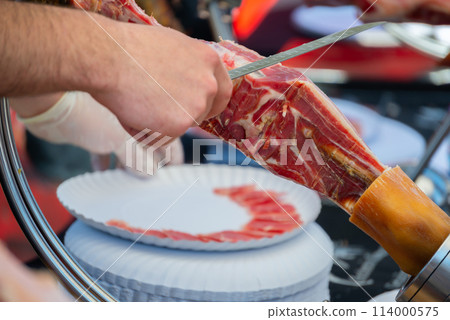 Ham cutting master, professional knife master, Cortador de jamon, man cutting jamon ham placed in a stand Ham cutting master, professional knife master, Cortador de jamon, man cutting jamon ham placed in a stand 114000575