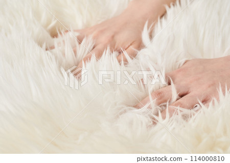 女人的手觸摸蓬鬆的布料 女人的手觸摸蓬鬆的布料 114000810