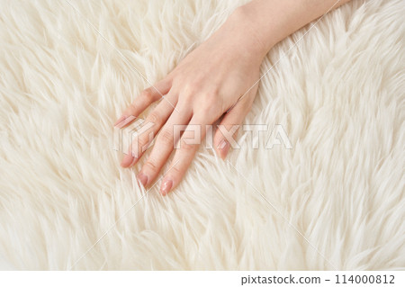 A woman's hands touching fluffy fabric 114000812