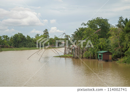 Fishing trap net in canal with fisherman urban city village town houses, lake or river. Nature landscape fisheries and fishing tools at Pak Pha, Songkhla, Thailand. Aquaculture farming Fishing trap net in canal with fisherman urban city village town houses, lake or river. Nature landscape fisheries and fishing tools at Pak Pha, Songkhla, Thailand. Aquaculture farming 114002741