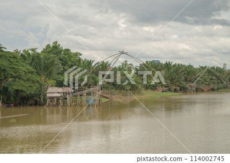 Fishing trap net in canal with fisherman urban city village town houses, lake or river. Nature landscape fisheries and fishing tools at Pak Pha, Songkhla, Thailand. Aquaculture farming Fishing trap net in canal with fisherman urban city village town houses, lake or river. Nature landscape fisheries and fishing tools at Pak Pha, Songkhla, Thailand. Aquaculture farming 114002745