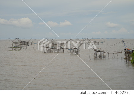 Fishing trap net in canal with fisherman urban city village town houses, lake or river. Nature landscape fisheries and fishing tools at Pak Pha, Songkhla, Thailand. Aquaculture farming Fishing trap net in canal with fisherman urban city village town houses, lake or river. Nature landscape fisheries and fishing tools at Pak Pha, Songkhla, Thailand. Aquaculture farming 114002753