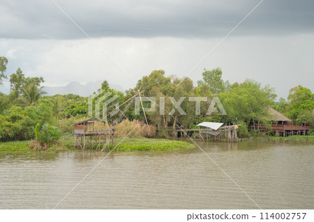 Fishing trap net in canal with fisherman urban city village town houses, lake or river. Nature landscape fisheries and fishing tools at Pak Pha, Songkhla, Thailand. Aquaculture farming Fishing trap net in canal with fisherman urban city village town houses, lake or river. Nature landscape fisheries and fishing tools at Pak Pha, Songkhla, Thailand. Aquaculture farming 114002757