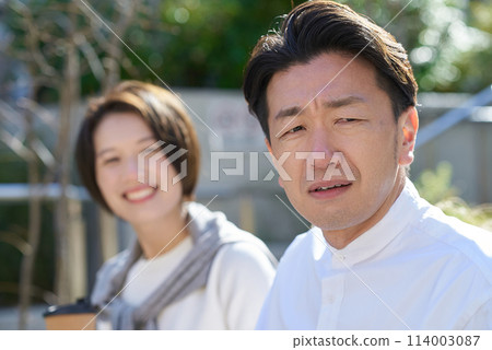 一個男人在一個女人旁邊看起來很不高興 114003087