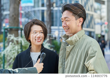 Men and women being interviewed on the street 114003776