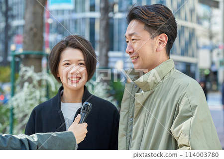Men and women being interviewed on the street 114003780