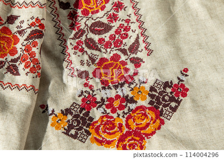Ukrainian clothes embroidered shirt. Red orange and black threads background. Vyshyvanka is a symbol of Ukraine. Embroidery cross stitching. National Ukrainian stitch. Traditional clothing symbol Ukrainian clothes embroidered shirt. Red orange and black threads background. Vyshyvanka is a symbol of Ukraine. Embroidery cross stitching. National Ukrainian stitch. Traditional clothing symbol 114004296