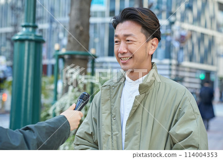 A man receiving a street interview A man receiving a street interview 114004353