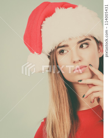 Thinking woman wearing Santa Claus helper costume 114005431