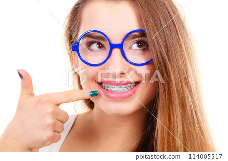 Happy nerdy teenage in eyeglasses showing braces 114005517