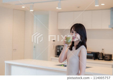 Young woman drinking a smoothie at home 114005757