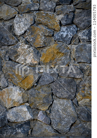 Granite stones of different shapes and colors. Wall cladding. Background selective focus with copy space. 2 Granite stones of different shapes and colors. Wall cladding. Background selective focus with copy space. 2 114005793