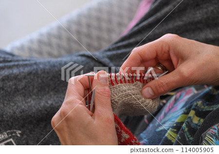woman's hands knit a sock with knitting needles. close-up 2 114005905